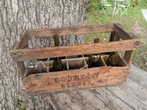 caisse à vin en bois avec guirlandes lumineuses et bouteilles de vin pour décoration de mariage