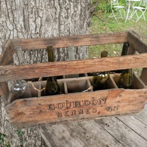 caisse à vin en bois avec guirlandes lumineuses et bouteilles de vin pour décoration de mariage